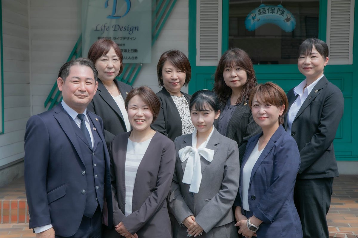 事務所の入口の前に並ぶライフデザインのスタッフ