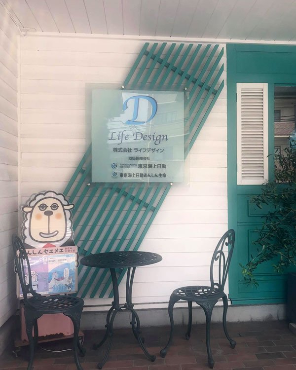 ライフデザインの事務所の入口。Life Design の看板、羊の人形、鉄の椅子とテーブル